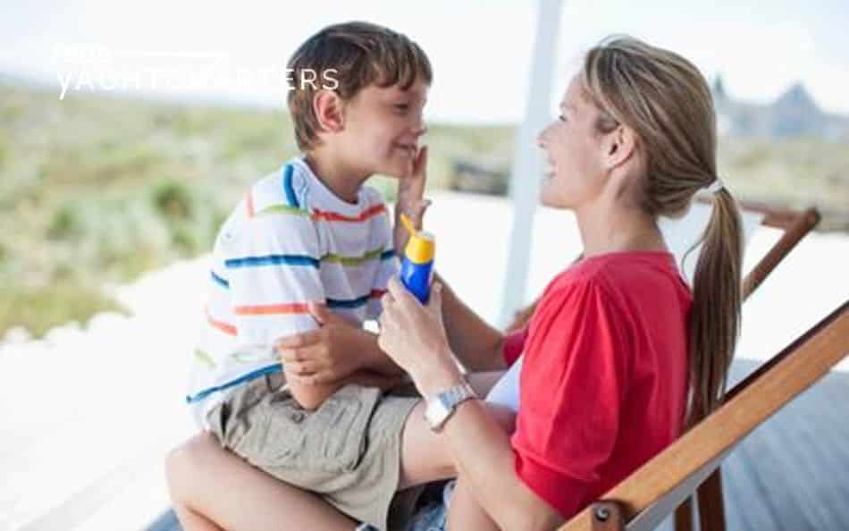 Photograph of a mother applying sunscreen to her little boy