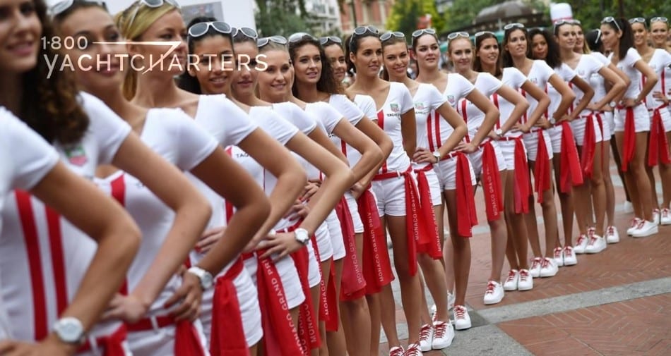 Photograph of girls dressed in red skirts, white shirts, and white heels, all standing in a straight line, with their hands on their hips.