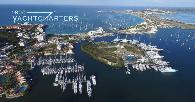 Aerial photograph of a marina in the Caribbean.  There are both sailboats and motoryachts in the marina.