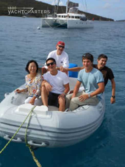 Photograph of family in an inflatable dinghy after happy yacht charter vacation. 