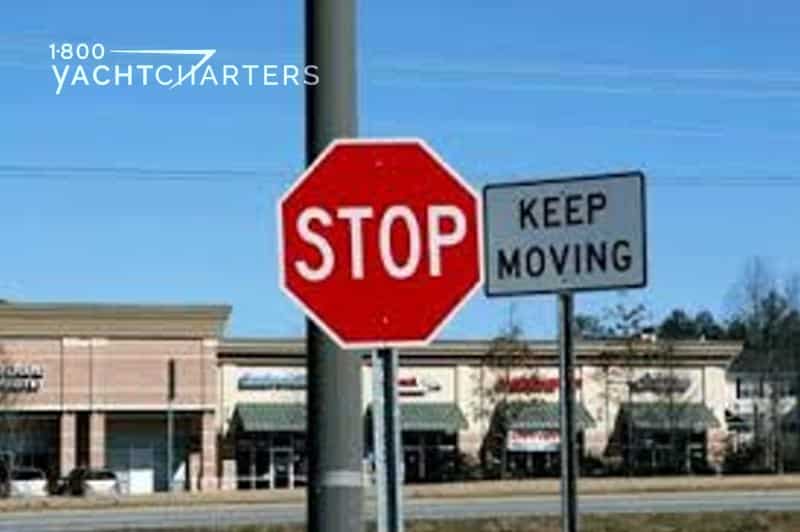 Photograph of a stop sign with a "keep moving" sign next to it.