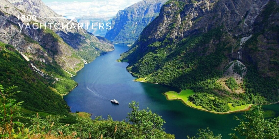 Photograph of fjord in Norway. Beautiful landscaping. Lush mountains beside a quiet river. Photo by Katrin Moe.
