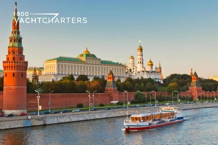 Photograph of Moscow, Russia, from across the river. The photo shows a river barge traveling down the river, toward the left. 
