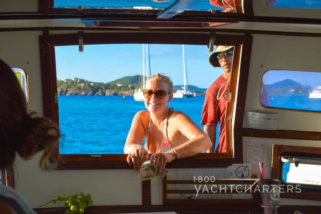 pizza boat virgin islands pick up window with smiling woman in bikini leaning on window to pick up pizza and man waiting behind her for order